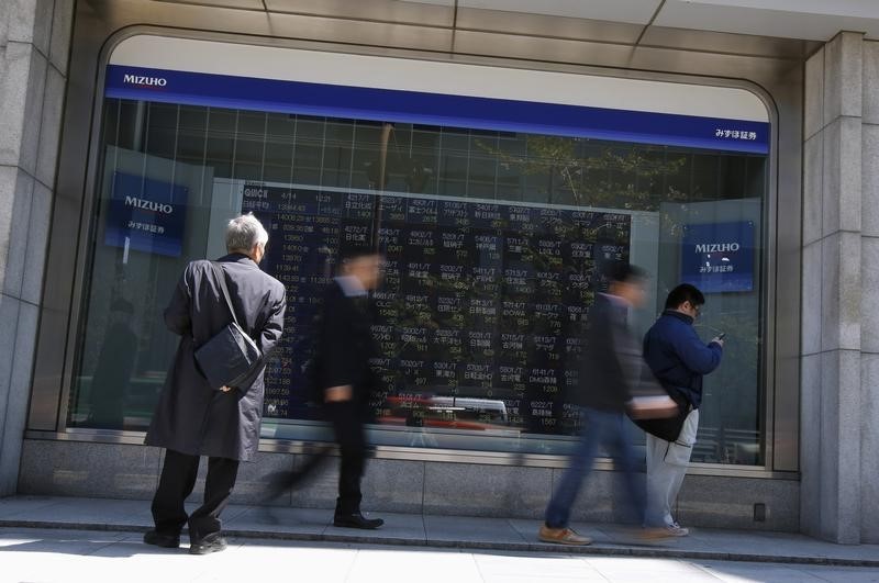 &copy; Reuters A man looks at a stock quotation board outside a brokerage in Tokyo