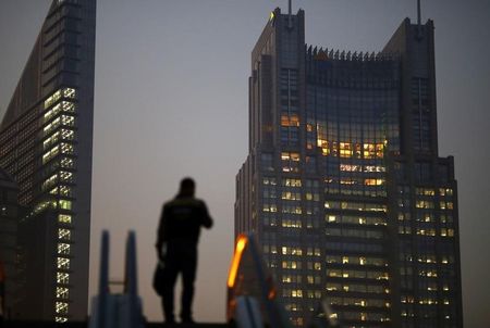 © Reuters. Man stands on an escalator in the financial district of Pudong in Shanghai