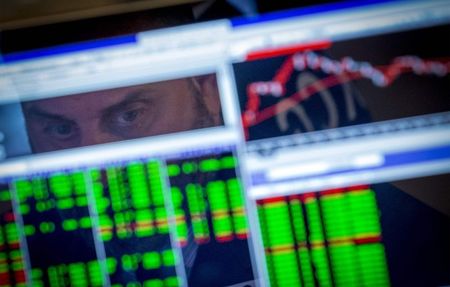 © Reuters. Il viso di un trader riflesso tra gli schermi dei pc in una sala operativa  