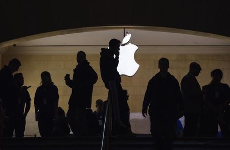 © Reuters. A man talks on his telephone as customers walk through an Apple store in Grand Central Terminal in New York