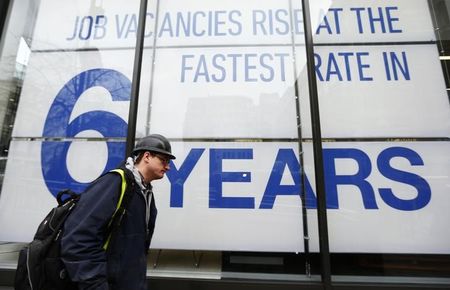 © Reuters. A man walks past the window of a recruitment agency in central London