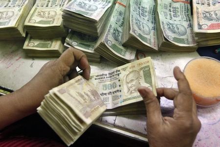 © Reuters. An employee counts Indian currency notes at a cash counter inside a bank in Kolkata