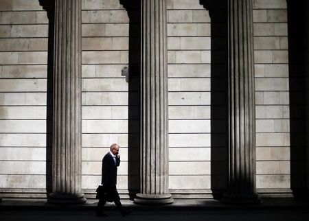 © Reuters. A man speaks on his phone on a sunny morning as he walks past the columns of the Bank of England in the City of London