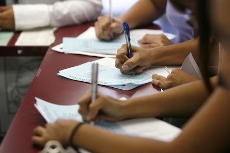 © Reuters. Applicants fill out forms during a job fair at the Southeast LA-Crenshaw WorkSource Center in Los Angeles