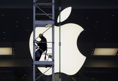 © Reuters. A worker climbs outside an Apple store in Hong Kong