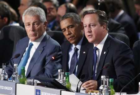 © Reuters. U.S. President Obama and U.S. Secretary of Defense Hagel listen to British Prime Minister Cameron speak as they participate in the NATO Summit Leaders? Meeting: Future NATO at the Celtic Manor Resort in Newport