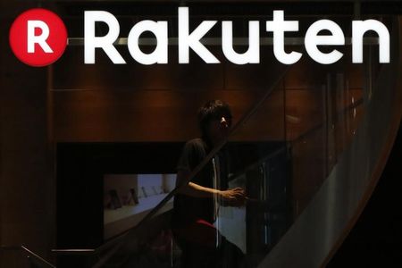 © Reuters. A staff of Rakuten Cafe is seen under a logo of Rakuten Inc in Tokyo