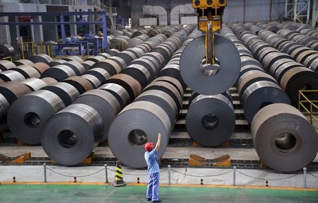 © Reuters. An employee guides a crane as it transports a roll of steel sheet, at a factory in Handan, Hebei