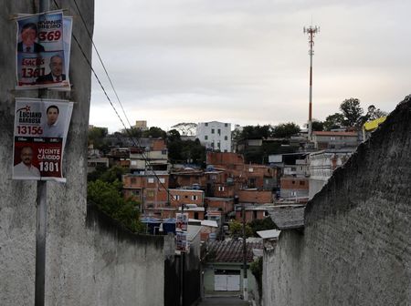 © Reuters. Election posters are seen hanging on a pole on a street of Jardim Sao Luis near the edge of Sao Paulo