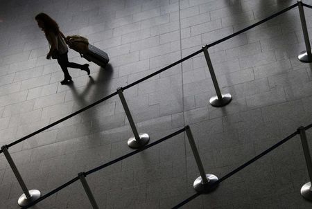 © Reuters. A flight passenger walks along an empty Lufthansa ticket counter during a strike at the Frankfurt airport, in Frankfurt