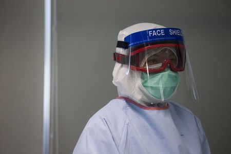 © Reuters. A doctor, wearing protective gear, takes part in a drill with a dummy to demonstrate the procedures of handling a patient afflicted with the Ebola virus, in Hong Kong