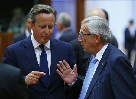 © Reuters. Britain's PM Cameron talks with newly elected European Commission President Juncker at the start of a European Union summit in Brussels