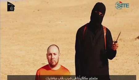 © Reuters. Still image from video of Sotloff kneeling next to a masked Islamic State fighter