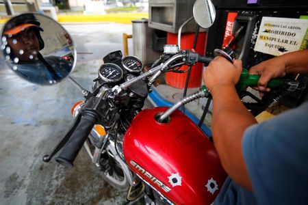 © Reuters. A man pumps gasoline at a service station in Caracas