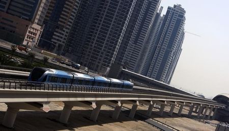 © Reuters. A Dubai Metro train runs past Sheikh Zayed road in Dubai