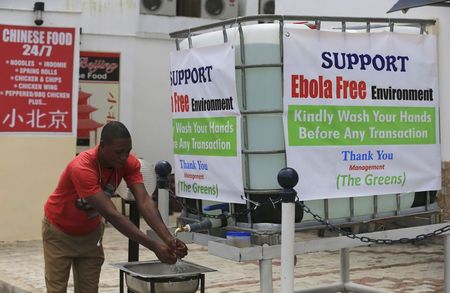 © Reuters. A man washes his hands at a tap outside the Green Pharmacy at Area 8 in Abuja