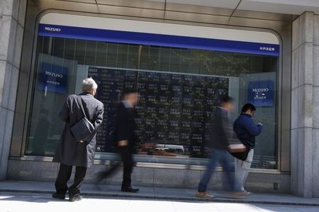 © Reuters. A man looks at a stock quotation board outside a brokerage in Tokyo