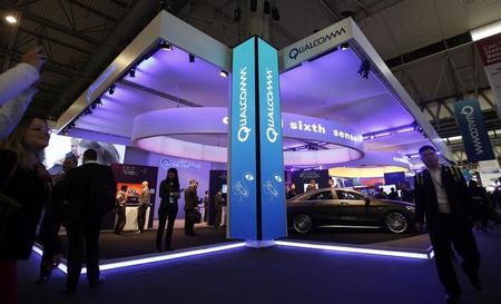 © Reuters. Visitors walk past the Qualcomm stand at the Mobile World Congress in Barcelona