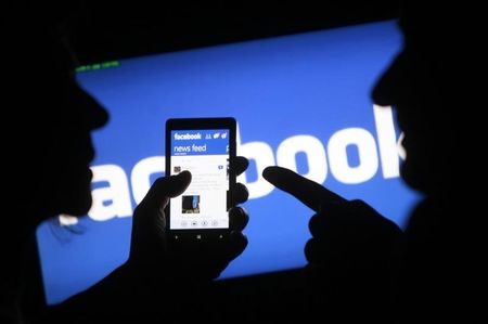 © Reuters. A smartphone user shows the Facebook application on his phone in Zenica, in this photo illustration