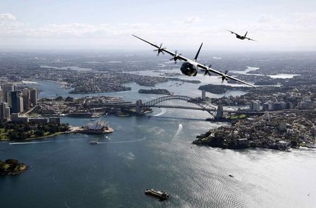 © Reuters. Handout shows Two Royal Australian Air Force C-130J Hercules aircraft flying above the Sydney Opera House and Sydney Harbour Bridge during a display