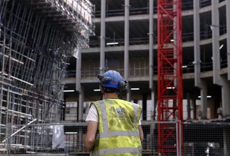 © Reuters. A worker walks through a construction site in central London