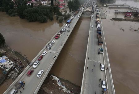 © Reuters. Vehicles wait in line on a highway over the flooded Jhelum river in Srinagar