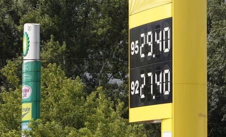 © Reuters. A gasoline station board displaying fuel prices stands beside a sign owned by a BP petrol station in Moscow