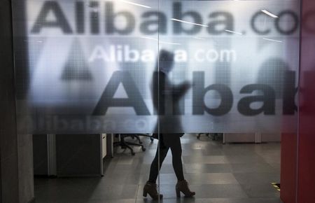 © Reuters. An employee is seen behind a glass wall with the logo of Alibaba at the company's headquarters on the outskirts of Hangzhou, Zhejiang province