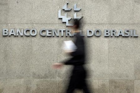 © Reuters. Homem passa pela logomarca do Banco Central na sede do banco em Brasília