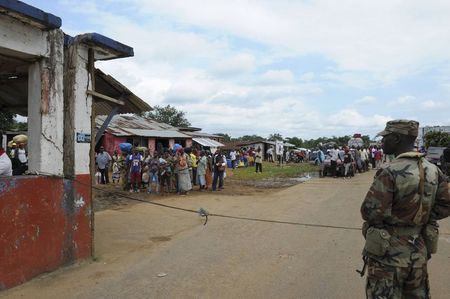 © Reuters. File photo of Liberian soldiers checking people travelling in Bomi County