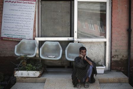 © Reuters. A fllood victim waits to receive treatment outside a hospital in Srinagar