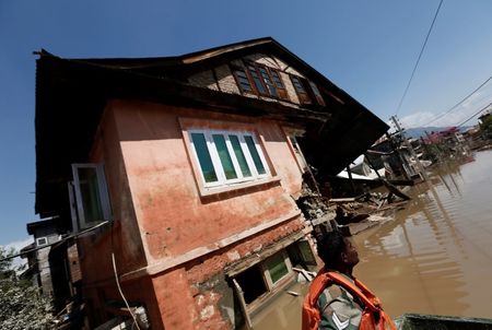 © Reuters. Un soldado del Ejército indio se desplaza en un bote de rescate frente a una casa anegada mientras busca a víctimas atrapadas por las inundaciones en Srinagar