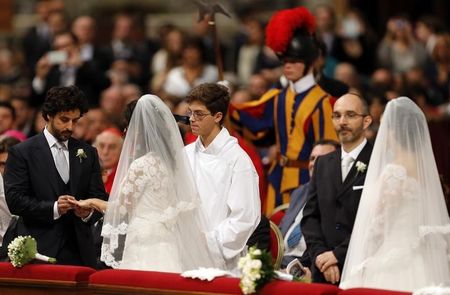 © Reuters. A groom exchanges rings with his bride during their wedding mass officiated by Pope Francis in St.Peter's Basilica at the Vatican