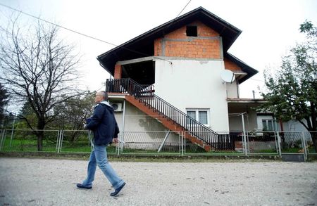 © Reuters. A man passes by the family residence of British aid worker David Haines in Sisak