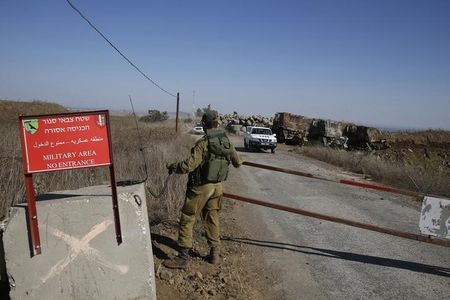 © Reuters. An Israeli soldier opens a gate as a U.N. convoy carrying Fijian U.N. peacekeepers released by al-Qaeda-linked group Nusra Front in Syria, drives towards Israeli-held territory on the Golan heights