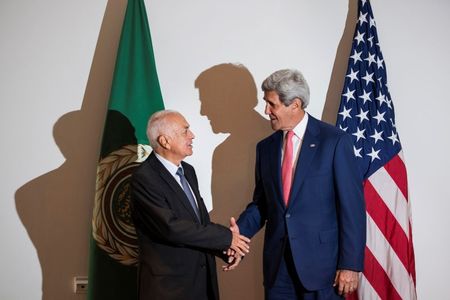 © Reuters. Arab League Secretary-General Nabil al-Araby and U.S. Secretary of State John Kerry shake hands before a meeting in Cairo