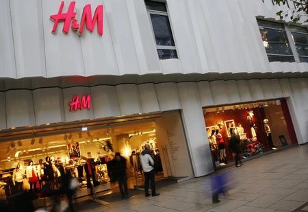 © Reuters. People walk past the window of an H&M textile shop in this longtime exposure photograph taken in Frankfurt