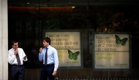© Reuters. Men speak near Portuguese Novo Banco (New Bank) posters at its head office in Lisbon