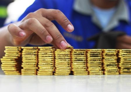 © Reuters. Сотрудник завода PT Antam Tbk сотртирует маленькие слитки золота в Джакарте