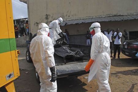 © Reuters. Health workers remove the body of Prince Nyentee, a man whom local residents said died of Ebola virus in Monrovia