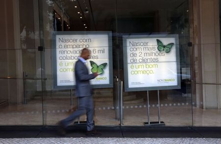 © Reuters. A man walks past Portuguese Novo Banco (New Bank) posters at its head office in Lisbon