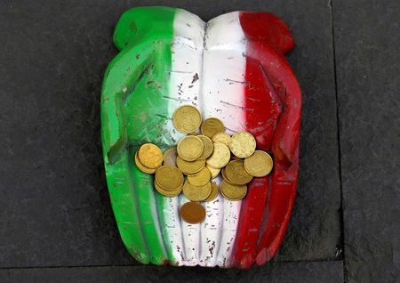 © Reuters. Euro coins are seen on the figure of a pair of hands on the ground in downtown Rome