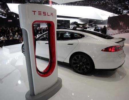 © Reuters. File of a Tesla S electric car and a charging station are displayed during the press preview day of the North American International Auto Show in Detroit