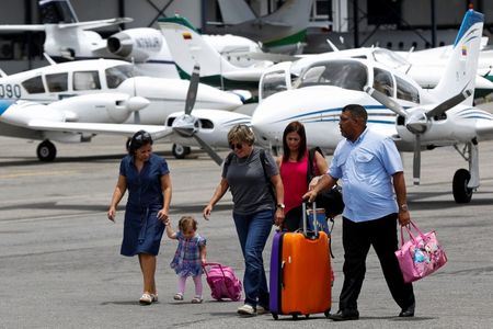 © Reuters. Passengers walk at the airstrip as they arrive at Charallave airport outside Caracas