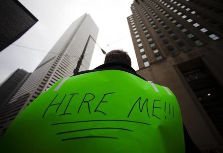 © Reuters. A man uses a megaphone to attract the attention of potential employers on Bay Street in the financial district in Toronto