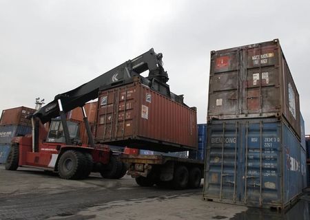 © Reuters. A machine places a container on a truck at a port in Hai Phong city