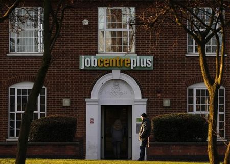 © Reuters. A man stands outside a state Job Centre employment office in Coalville, central England