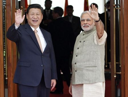 © Reuters. India's PM Modi and China's President Xi wave before their meeting in Ahmedabad