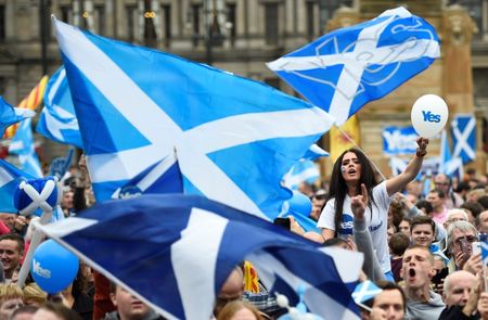 © Reuters. Campaigners wave Scottish Saltires at a 'Yes' campaign rally in Glasgow