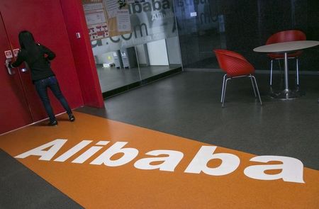 © Reuters. A woman stands next to a door inside the headquarters of Alibaba in Hangzhou